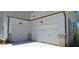 Two-car garage with carriage doors and brick base, with painted siding and black exterior lights at 4515 Aiden Way, Cumming, GA 30041
