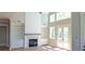 Open-concept living room with fireplace, built-in shelving, lots of light, and double doors to outdoor at 4515 Aiden Way, Cumming, GA 30041