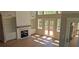Spacious living room featuring fireplace, built-in shelving, hardwood floors, and access to outdoor deck at 4515 Aiden Way, Cumming, GA 30041