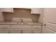 Stylish wet bar with white cabinets and drawers and a granite countertop at 4515 Aiden Way, Cumming, GA 30041