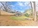 Landscaped backyard featuring a wooden deck, a grassy area, and mature trees, creating a serene outdoor space at 389 Kendrick Se Ave, Atlanta, GA 30315