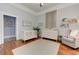 Bright bedroom featuring a white crib, fireplace, and a comfortable chair with wood flooring at 389 Kendrick Se Ave, Atlanta, GA 30315