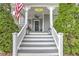 Inviting front porch with an American flag, black lanterns, seating and manicured landscaping at 389 Kendrick Se Ave, Atlanta, GA 30315