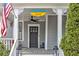 Inviting front porch with an American flag, black lanterns, seating and manicured landscaping at 389 Kendrick Se Ave, Atlanta, GA 30315