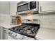 Close up of kitchen with a stainless steel gas range and microwave, and quartz countertops at 389 Kendrick Se Ave, Atlanta, GA 30315