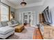 Comfortable living room features hardwood floors, gray sofa, and access to dining room through glass paneled doors at 389 Kendrick Se Ave, Atlanta, GA 30315