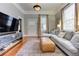 Bright living room boasts a gray sectional sofa, leather ottoman, hardwood floors, and a modern TV console at 389 Kendrick Se Ave, Atlanta, GA 30315