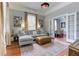 Cozy living room with gray sofa, leather ottoman, hardwood floors, and glass doors leading to the dining room at 389 Kendrick Se Ave, Atlanta, GA 30315