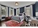 Spacious bedroom with dark blue walls, a metal bed frame, and an area rug at 115 17Th Street Ne, Atlanta, GA 30309