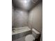 Bathroom with a bathtub, toilet, and marble-tiled shower surround at 269 Lakeside Pl, Canton, GA 30114