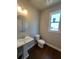 Powder room with pedestal sink, toilet, and hardwood floor at 269 Lakeside Pl, Canton, GA 30114