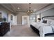 Spacious main bedroom with tray ceiling, carpet flooring, and decorative light fixture at 11360 Bennett Ln, Johns Creek, GA 30097
