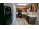 Kitchen with dark wood cabinets, black appliances, and vinyl flooring at 6627 Coventry Pt, Austell, GA 30168