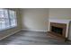 Living room featuring a brick fireplace and grey vinyl plank flooring at 6627 Coventry Pt, Austell, GA 30168
