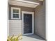 Black front door with white trim and sidelight window at 8631 Paradise Dr, Douglasville, GA 30134