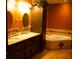 Bathroom featuring double sinks, granite countertops, a soaking tub, and plenty of storage at 10252 Commons Xing, Jonesboro, GA 30238