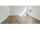 Sunlit bedroom with light wood floors, white walls, window with blinds, and white door at 11335 Bennett Ln, Johns Creek, GA 30097