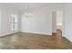 Bright dining room with hardwood floors, modern chandelier, and an open doorway at 11335 Bennett Ln, Johns Creek, GA 30097