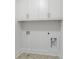 Cozy laundry room with white cabinets and patterned tile floors at 11335 Bennett Ln, Johns Creek, GA 30097
