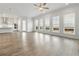 Bright living room flows into a kitchen area offering ample windows and wood-look flooring for a stylish look at 11335 Bennett Ln, Johns Creek, GA 30097