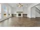Spacious living room is enhanced by a fireplace, many windows and wood look flooring, perfect for gatherings at 11335 Bennett Ln, Johns Creek, GA 30097