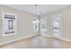Bright dining room with light hardwood floors, modern chandelier, and many windows for natural light at 161 Mooney Rd, Woodstock, GA 30188