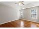 Bedroom featuring tray ceiling, hardwood floors and a large window at 1012 Crown River Pkwy, Mcdonough, GA 30252