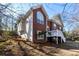 A two-story brick home featuring a deck with white railings, large windows, and lush landscaping at 1012 Crown River Pkwy, Mcdonough, GA 30252