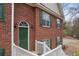Close-up of the home's entrance, showcasing a green front door, brick facade, and white trim at 1012 Crown River Pkwy, Mcdonough, GA 30252