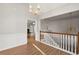 Open foyer with hardwood floors and chandelier overlooking the living space and staircase at 1012 Crown River Pkwy, Mcdonough, GA 30252