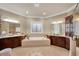 This spacious bathroom features a large soaking tub, dual vanities, and beautiful tile flooring at 511 Baxter Way, Marietta, GA 30064