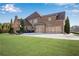 Home's rear elevation, showcasing a three-car garage and yard at 511 Baxter Way, Marietta, GA 30064