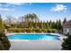 Beautiful backyard pool area, perfect for relaxation and entertaining with lovely plantings and blue sky at 511 Baxter Way, Marietta, GA 30064