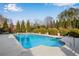 A beautiful in-ground pool surrounded by a concrete patio, lush landscaping and a metal safety fence at 511 Baxter Way, Marietta, GA 30064