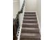 Staircase with dark wood railing and neutral carpeting at 2398 Ticonic Rd, Lithonia, GA 30058