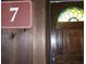 View of the home's front door with a stained glass window and a sign with the number 7 at 7 Quail Run, Decatur, GA 30035