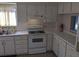 Functional kitchen with classic white cabinets and standard appliances at 7 Quail Run, Decatur, GA 30035