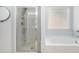 Bright, clean bathroom featuring a glass-enclosed shower, soaking tub, and frosted window for privacy at 202 Bryon Ln, Acworth, GA 30102