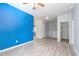 Upstairs bonus room featuring grey laminate flooring, a blue accent wall and a ceiling fan at 202 Bryon Ln, Acworth, GA 30102