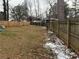 Large fenced backyard with a grassy area, some leaf debris, and a bit of snow at 2615 Leeshire Ct # 1, Tucker, GA 30084