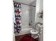 Bathroom with a shower and tub combo, white marble tile, and red geometric shower curtain at 2615 Leeshire Ct # 1, Tucker, GA 30084