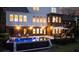 Night view of a luxurious pool and patio with a modern home in the background at 225 Blueberry Rdg, Milton, GA 30075