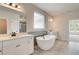 Bathroom with a large soaking tub, double vanity, and grey tile at 508 Dolce Rd, Locust Grove, GA 30248