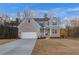 Two-story home with gray siding, brick accents, and a three-car garage at 508 Dolce Rd, Locust Grove, GA 30248