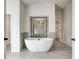 Modern bathroom featuring soaking tub and tiled shower with a large glass panel at 203 Arabella Pkwy, Locust Grove, GA 30248