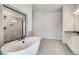 Luxurious bathroom featuring an elegant soaking tub, tiled shower and vanity at 203 Arabella Pkwy, Locust Grove, GA 30248