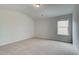 Bright bedroom with neutral walls and carpet, featuring a window with natural light at 203 Arabella Pkwy, Locust Grove, GA 30248