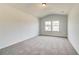 Bright bedroom with vaulted ceiling, plush carpet, and double windows offering natural light at 203 Arabella Pkwy, Locust Grove, GA 30248