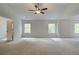 Large bedroom with ceiling fan, carpet, and two windows offering natural light at 203 Arabella Pkwy, Locust Grove, GA 30248