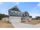 Charming two-story home showcasing navy siding, a two-car garage, stone accents, and manicured landscaping at 203 Arabella Pkwy, Locust Grove, GA 30248